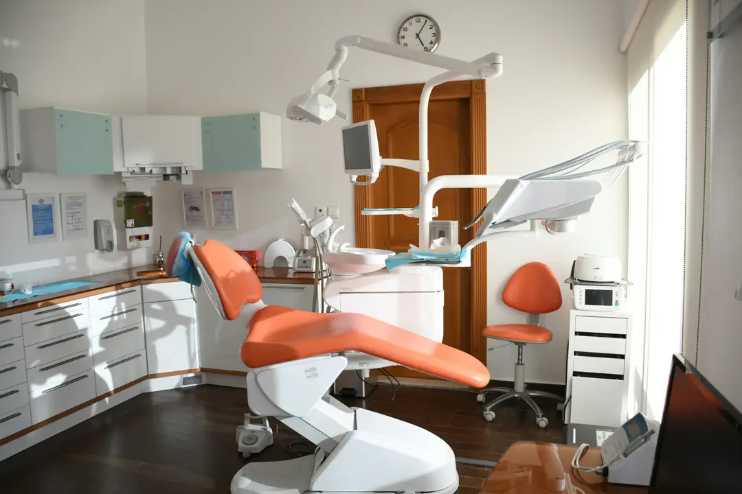Consultorio dental con sillón naranja e iluminación natural